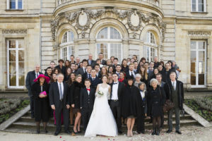 Photo de groupe de mariage famille et invités autour du couple de jeunes mariés à la mairie de Talence dans le parc Peixoto par le photographe de mariage à bordeaux Sebastien Huruguen