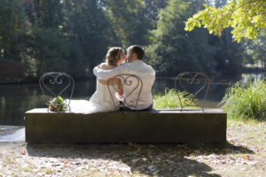 couple de mariés qui s'embrassent sur un banc du parc Majolan à Blanquefort lors de leur séance photo de couple Trash The Dress Day After en Gironde sous l'oeil du photographe de mariage à Bordeaux Sébastien Huruguen
