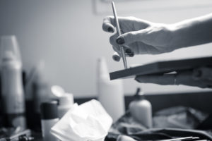 Jolie photo en noir et blanc des mains de la maquilleuse professionnelle qui maquille la future mariée lors des préparatifs le jour de son mariage sebastien huruguen