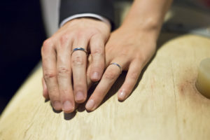 Photographe Mariage Bordeaux Sebastien Huruguen alliances anneaux main dans la main sur un tonneau barrique de vin cave chateau lafitte laguens yvrac