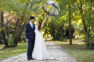 comment choisir son photographe de mariage pas cher conseils sebastien huruguen photographe mariage bordeaux couple de jeunes mariés avec une ombrelle lors de leur séance photo trash the dress au parc majolan de blanquefort - Sébastien Huruguen Photographe Mariage Bordeaux