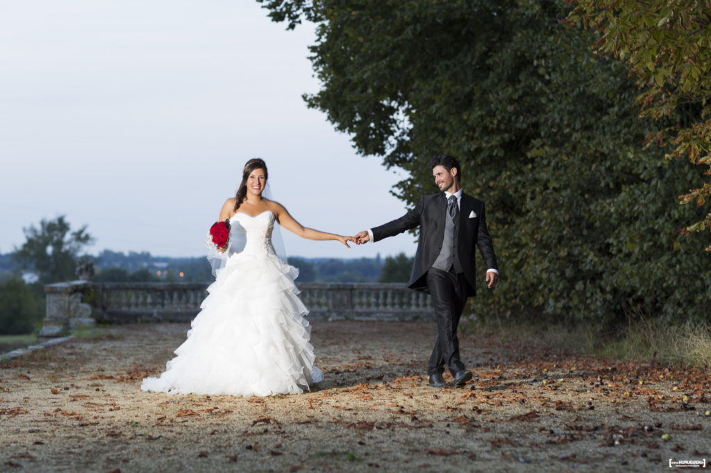 Couple de jeunes mariés se tenant par la main au Chateau La Dame Blanche Le Taillan Médoc dans la région de Bordeaux Sebastien Huruguen photographe mariage