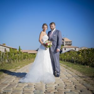 Couple de jeunes mariés en costume et robe de mariage blanche devant le Chateau Smith Haut Lafitte à Bordeaux par Sébastien Huruguen photographe Mariage, tarifs album photo de mariage bordeaux, tarif livre album photo mariage