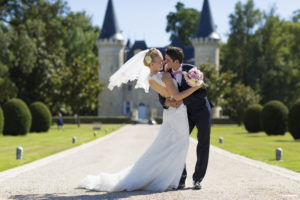 couple de jeunes mariés heureux qui s'embrassent devant le chateau d'Agassac à Ludon-Médoc dans la région de Bordeaux immortalisé par le photographe professionnel de mariage Sebastien Huruguen
