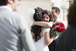 mariée serrée dans les bras de ses amies qui la félicitent pour son mariage