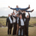 les témoins portent le jeune marié et le font sauter en l'air mariage château haut-bourcier blaye gironde sebastien huruguen photographe bordeaux