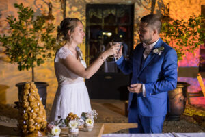 Sebastien Huruguen photographe de Mariage à Bordeaux et en Gironde couple de mariés qui trinquent au champagne devant la pièce montée