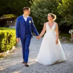 Mariés A & M marchant vers le Manoir de Saint-Gervais à Saint-André-de-Cubzac sous une lumière de fin de journée.